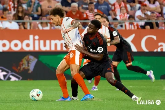 Agoumé pugna por un balón con Witsel en el Sevilla - Girona